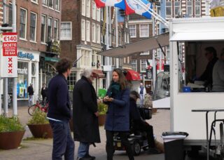 Dutch family standing near a food truck; locate birth parents in Netherlands concept